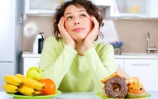 healthy - woman deciding btwn donuts and fruit