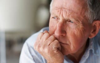 Closeup of an elderly man looking away in deep thought , depression