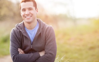 Portrait of a smiling young man standing outside
