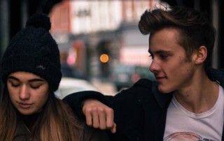 Teen couple in back of car