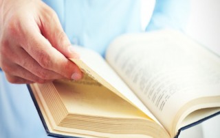 man holding open blue book