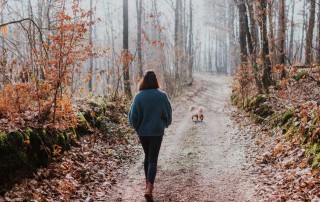 woman walking dog down path