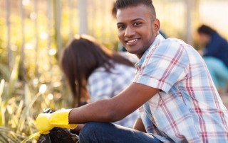 young man picking up litter with group