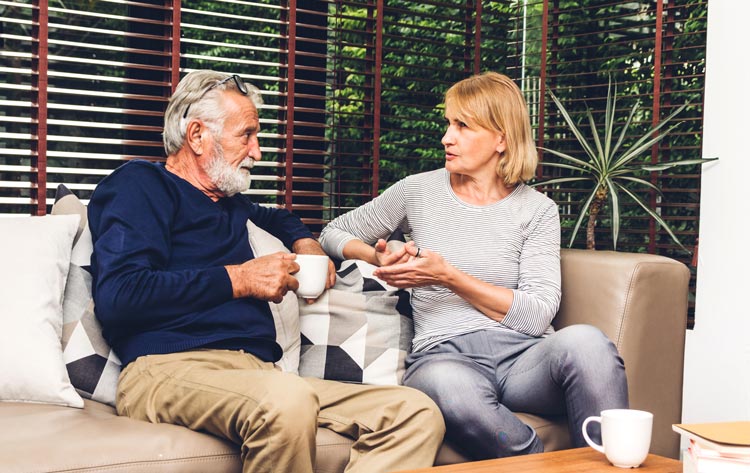 senior couple talking on couch at home