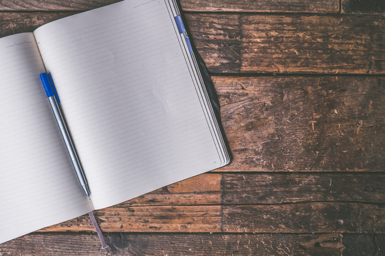 blank journal laying open on wooden table - journal