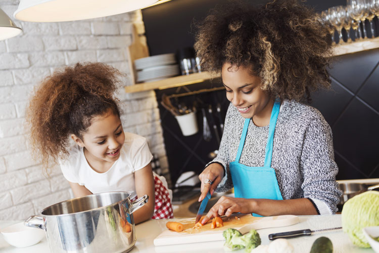 beautiful mother and daughter cooking in kitchen together - mother