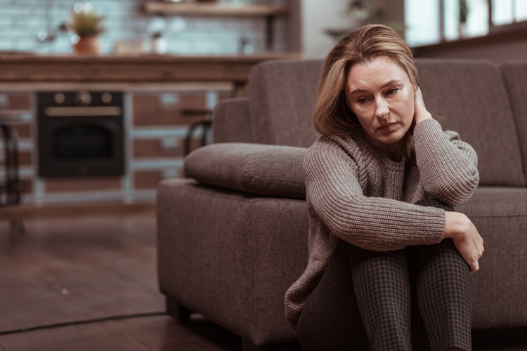 sad woman sitting on floor at home - your recovery