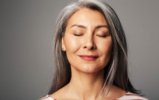 Practicing Radical Acceptance, beautiful older woman with her eyes closed, smiling slightly - radical acceptance