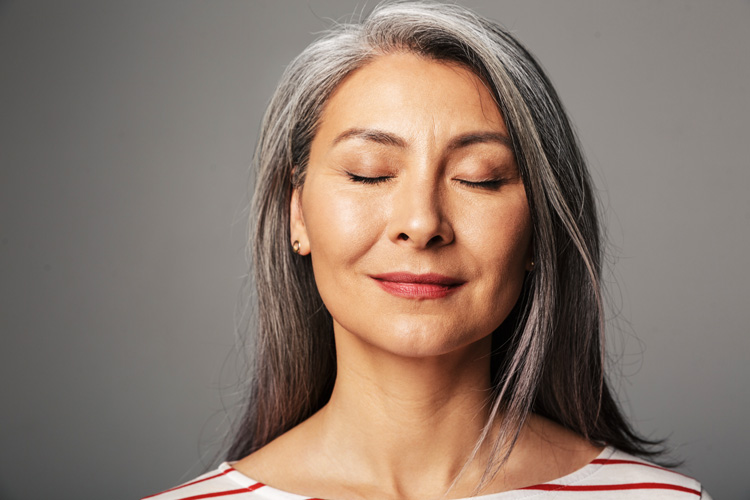 Practicing Radical Acceptance, beautiful older woman with her eyes closed, smiling slightly - radical acceptance