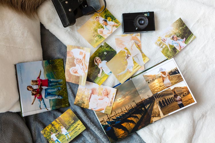 photographs laid out on bed or table - grief