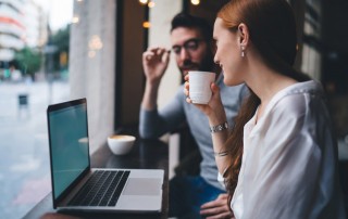 woman and man sitting and talking while looking at laptop together - friend and rehab