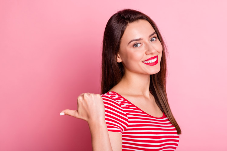 pretty smiling dark haired young woman gesturing with her thumb - going to rehab