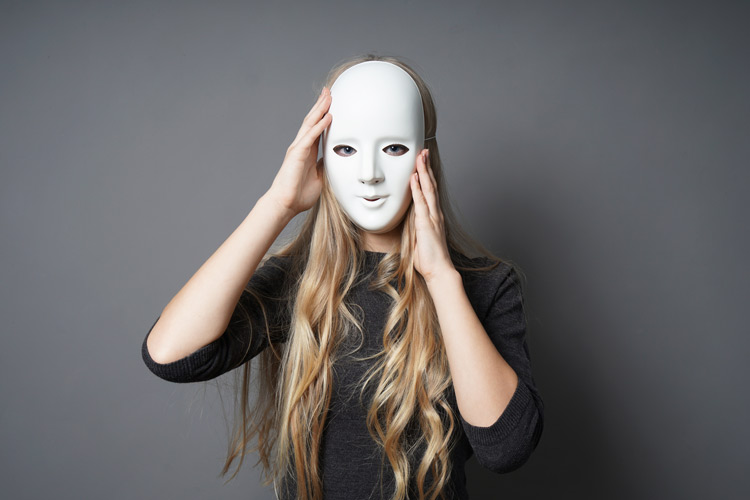 woman with long blonde hair holding a plain white mask up to her face - addictive personality