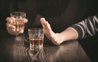A person's hand pushing away alcohol.